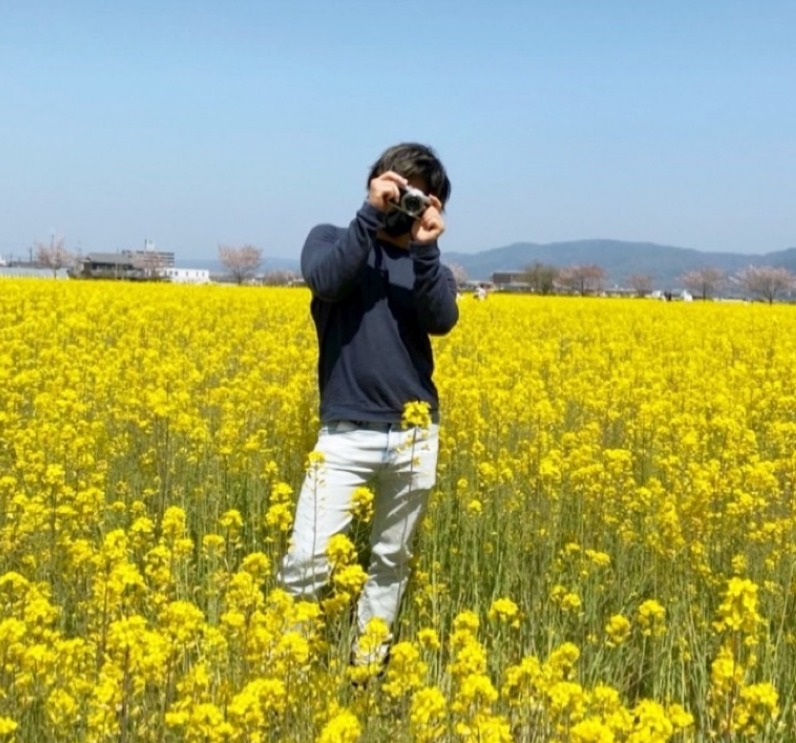 菜の花畑に立つ後藤さん
